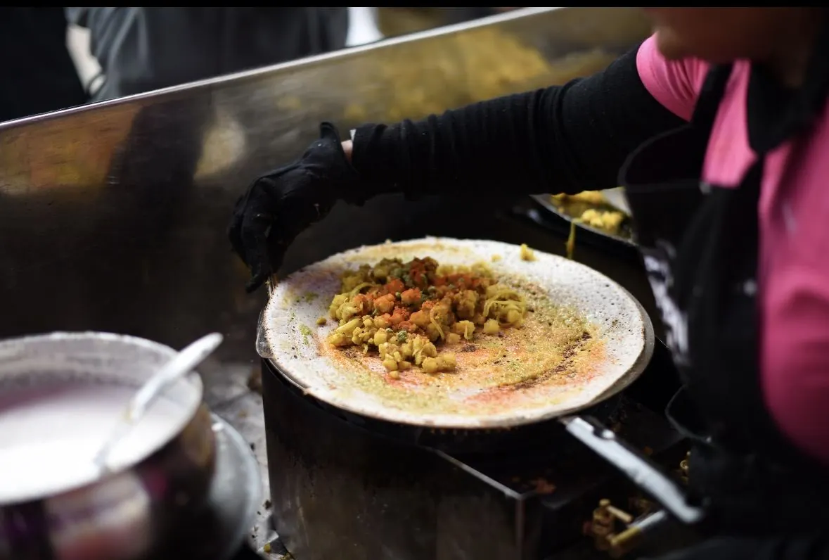 Mumbai Mix adding spiced potato filling to a dosa on the griddle